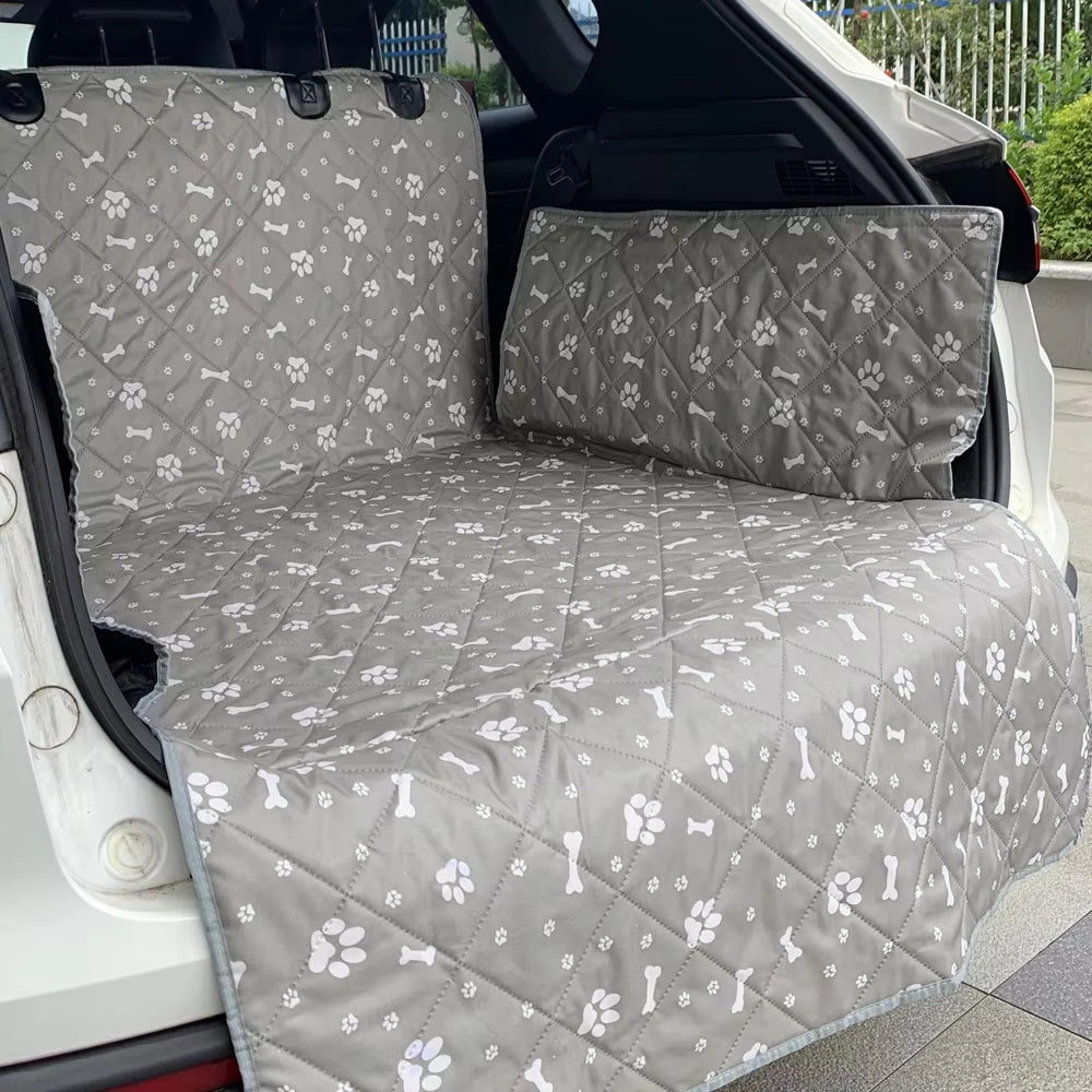 Grey paw-print liner spread across the rear bench seat of a car